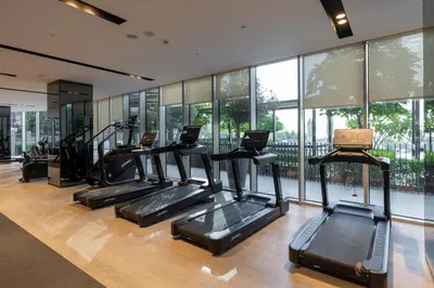 a gym with several treadmills in a room with windows at Maison Privee - Sky-High Elegance with Unrivaled Burj Khalifa Views in Dubai