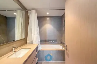 a bathroom with a tub and a sink and a mirror at Steps from Dubai Mall Enjoy Dubai Skyline from Balcony Luxury 2 Bedroom Like Home in Dubai