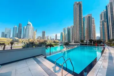 a large swimming pool with a city skyline in the background at Steps from Dubai Mall Enjoy Dubai Skyline from Balcony Luxury 2 Bedroom Like Home in Dubai