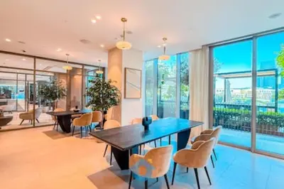 a dining room with a table and chairs and windows at Steps from Dubai Mall Enjoy Dubai Skyline from Balcony Luxury 2 Bedroom Like Home in Dubai