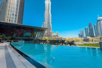 a large swimming pool in a city with tall buildings at Steps from Dubai Mall Enjoy Dubai Skyline from Balcony Luxury 2 Bedroom Like Home in Dubai