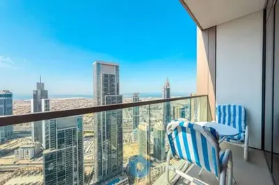 a balcony with two chairs and a view of a city at Next to Burj Khalifa & Dubai Mall - Enjoy Dubai Skyline Luxury 2BR Like Home in Dubai