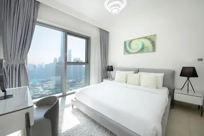 a bedroom with a white bed and a large window at Silk Valley - Luxury 2B with iconic Burj Khalifa views and walk to Dubai Mall in Dubai