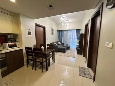 a kitchen and a living room with a table and chairs at Luxurious 2bhk apartment in Business Bay in Dubai