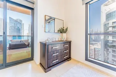 a bedroom with a dresser and a large window at Terrace and Marina Views 1BR Near JBR, Ain Dubai and Major Landmarks, Zumurud, Dubai Marina by Deluxe Holiday Homes in Dubai