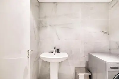 a white bathroom with a sink and a toilet at Luxury 2BR Stay in DIFC, Steps to Gate Avenue and Dubai Mall in Dubai
