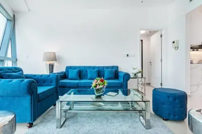 a living room with blue couches and a glass table at Luxury 2BR Stay in DIFC, Steps to Gate Avenue and Dubai Mall in Dubai