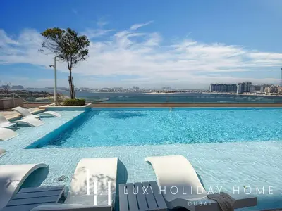 a swimming pool with chairs and a view of the city at LUX The Beach Vista Dubai Eye View Suite in Dubai