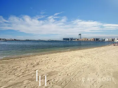 a beach with the ocean and a city in the background at LUX The Beach Vista Dubai Eye View Suite in Dubai