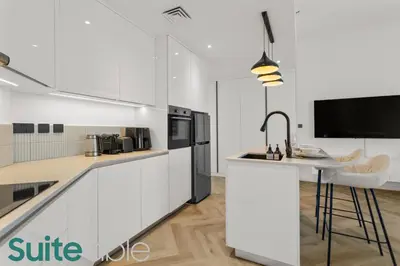 a kitchen with white cabinets and a counter top at Spacious refurbished Studio steps away from metro in Dubai