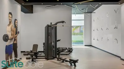 a room with a gym with cardio equipment in it at Spacious refurbished Studio steps away from metro in Dubai