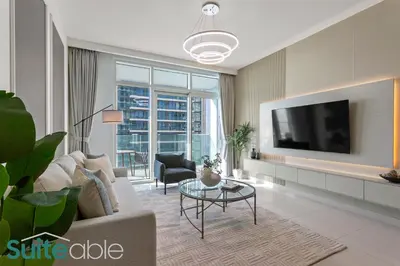 a living room with a couch and a tv at Breathtaking Elegance 1Bedroom in Emaar Beachfront in Dubai