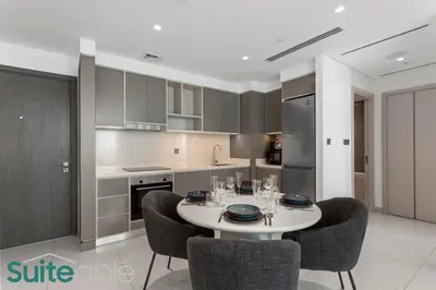 a kitchen with a white table and chairs in a room at Breathtaking Elegance 1Bedroom in Emaar Beachfront in Dubai