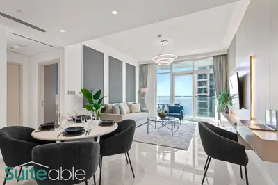a living room with a table and chairs and a couch at Breathtaking Elegance 1Bedroom in Emaar Beachfront in Dubai