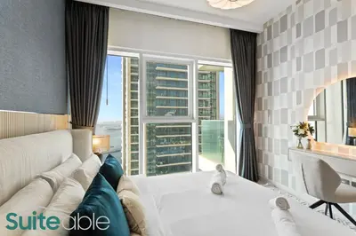 a living room with a couch and a large window at Breathtaking Elegance 1Bedroom in Emaar Beachfront in Dubai