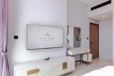 a white bedroom with a vanity and a mirror at Luxury 1BR at Binghatti Onyx JVC in Dubai