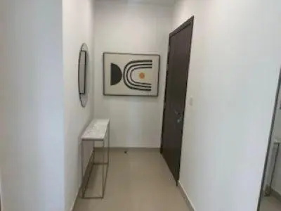a hallway with a table and a door in a room at Hideaway in Downtown in Dubai