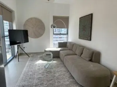 a living room with a couch and a flat screen tv at Hideaway in Downtown in Dubai