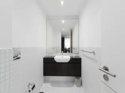 a white bathroom with a sink and a mirror at Short stay Limestone House DIFC 2 bedrooms in Dubai