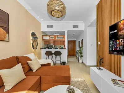 a living room with a brown couch and a kitchen at Luxurious Home in the heart of Dubai Marina in Dubai