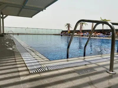 a swimming pool with a ramp leading into the water at Private Apartment in Novotel JVT Comfort for 4 Guests in Dubai