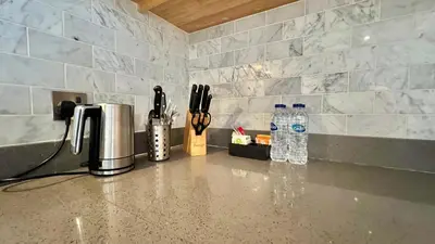 a kitchen counter with a sink with knives and bottles of water at Private Apartment in Novotel JVT Comfort for 4 Guests in Dubai