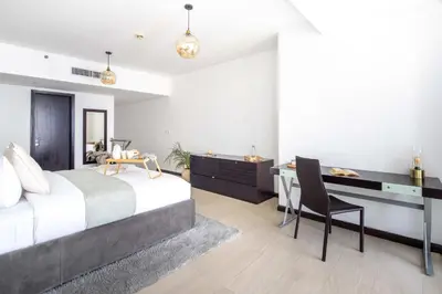 a bedroom with a bed and a desk and a table at Frank Porter - Laguna Tower in Dubai