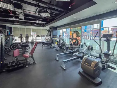 a gym with several tread machines and a large mural at Frank Porter - Laguna Tower in Dubai