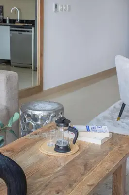 a coffee pot on a wooden table in a living room at Frank Porter - Laguna Tower in Dubai