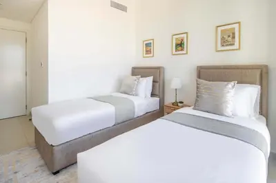 two beds in a hotel room with white walls at Frank Porter - Downtown Views II in Dubai
