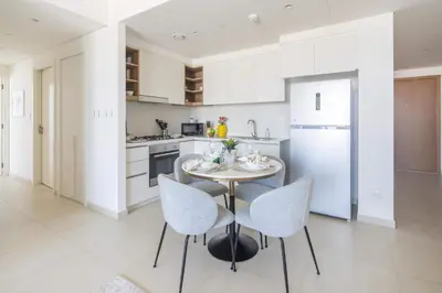a kitchen with a table and chairs and a refrigerator at Frank Porter - Downtown Views II in Dubai