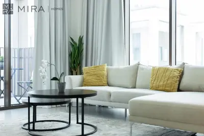 a living room with a white couch and a table at Mira Holiday Homes - Cosy 1BHK in the heart of Dubai Creek Harbour in Dubai