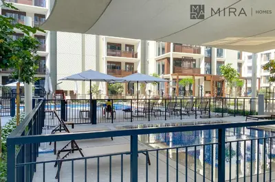 a pool with chairs and umbrellas in a building at Mira Holiday Homes - Cosy 1BHK in the heart of Dubai Creek Harbour in Dubai