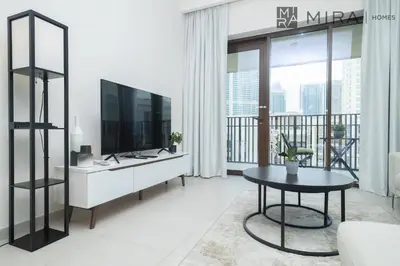 a living room with a television and a table at Mira Holiday Homes - Cosy 1BHK in the heart of Dubai Creek Harbour in Dubai