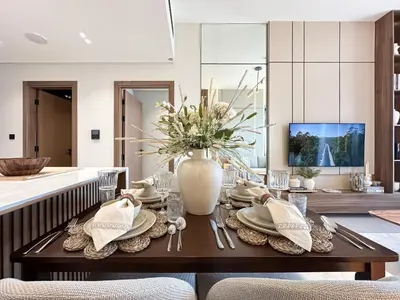 a dining room with a table with a vase of flowers at Trophy-Cultivate Retreat with Statement Design in Dubai