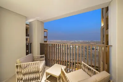 a balcony with two chairs and a view of the city at FIRST CLASS 1BR Glamorous & Stylish Escape in Dubai