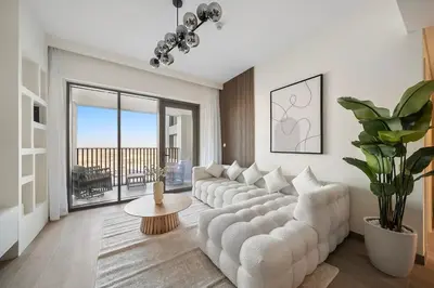 a living room with a white couch and a large window at FIRST CLASS 1BR Glamorous & Stylish Escape in Dubai