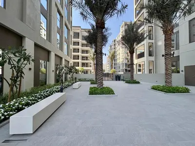 a courtyard with palm trees and benches in a building at FIRST CLASS 1BR Glamorous & Stylish Escape in Dubai