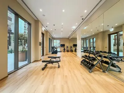 a gym with a row of treadmills and exercise bikes at FIRST CLASS 1BR Glamorous & Stylish Escape in Dubai