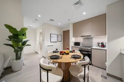 a kitchen with a table and chairs in a room at FIRST CLASS 1BR Glamorous & Stylish Escape in Dubai