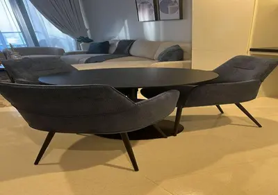 a table and chairs in a living room with a couch at Aykon city 2BHK beach city view in Dubai