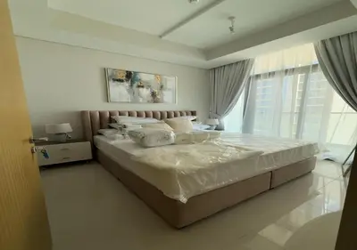 a bedroom with a large bed with white sheets and pillows at Aykon city 2BHK beach city view in Dubai