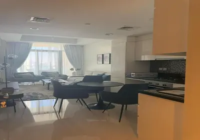 a kitchen and living room with a table and chairs at Aykon city 2BHK beach city view in Dubai