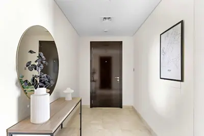 a hallway with a mirror and a table with a vase at Silkhaus Premium 1BR at Sky Gardens in Heart of DIFC in Dubai