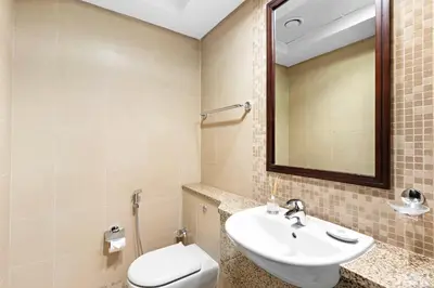 a bathroom with a sink and a toilet and a mirror at Silkhaus Premium 1BR at Sky Gardens in Heart of DIFC in Dubai