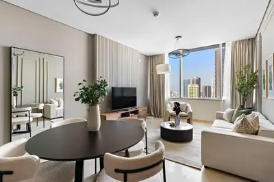 a living room with a couch and a table and chairs at Silkhaus Premium 1BR at Sky Gardens in Heart of DIFC in Dubai