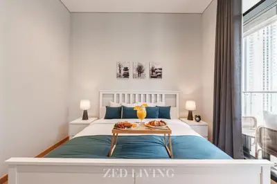 a bedroom with a bed with a tray of food on it at RP Heights - Luxe 2BR with Burj Khalifa View - Zed Living in Dubai