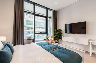 a bedroom with a large window and a tv at RP Heights - Luxe 2BR with Burj Khalifa View - Zed Living in Dubai