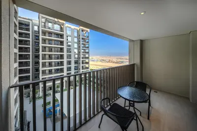 a balcony with a table and chairs and a view of a city at Elegant 1 Bedroom in Orchid at Creek Beach in Dubai
