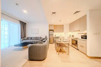 a kitchen and living room with a couch and a table at Elegant 1 Bedroom in Orchid at Creek Beach in Dubai